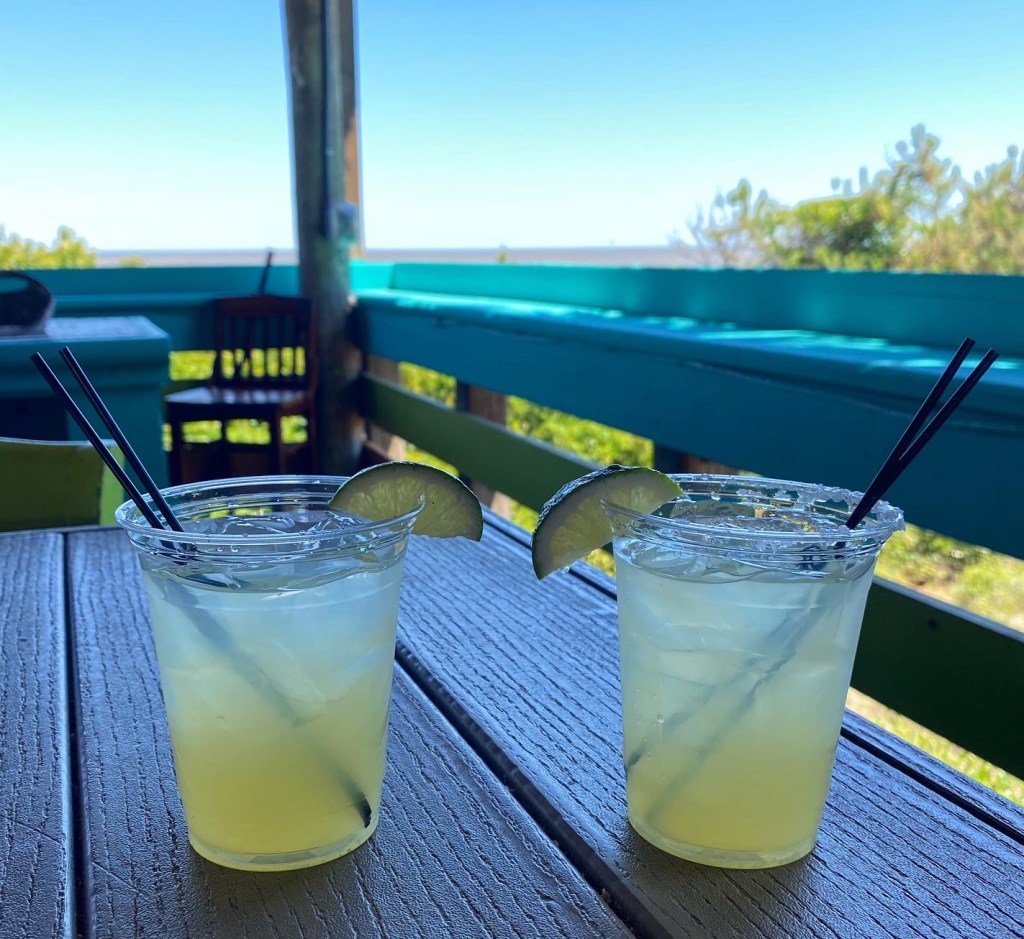 Two cups of margarita on the rocks from Tortuga Jacks, overlooking an ocean view